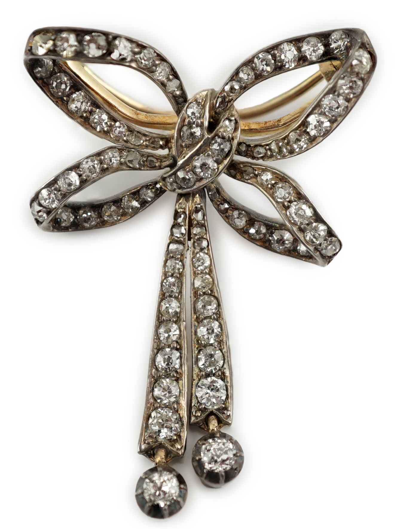An Edwardian gold, silver and graduated diamond cluster set twin drop ribbon bow brooch